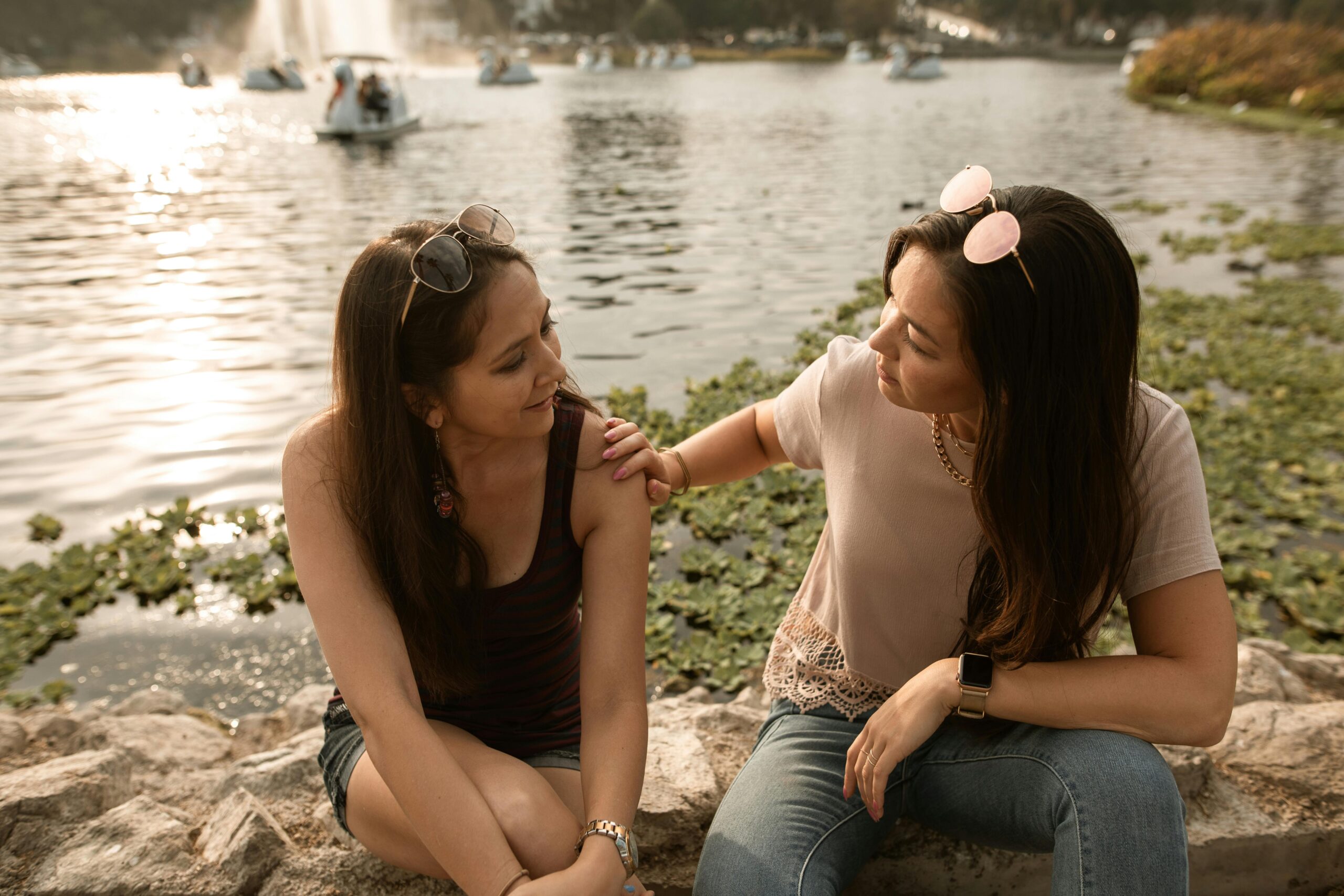 woman touching another womans arm in caring way
